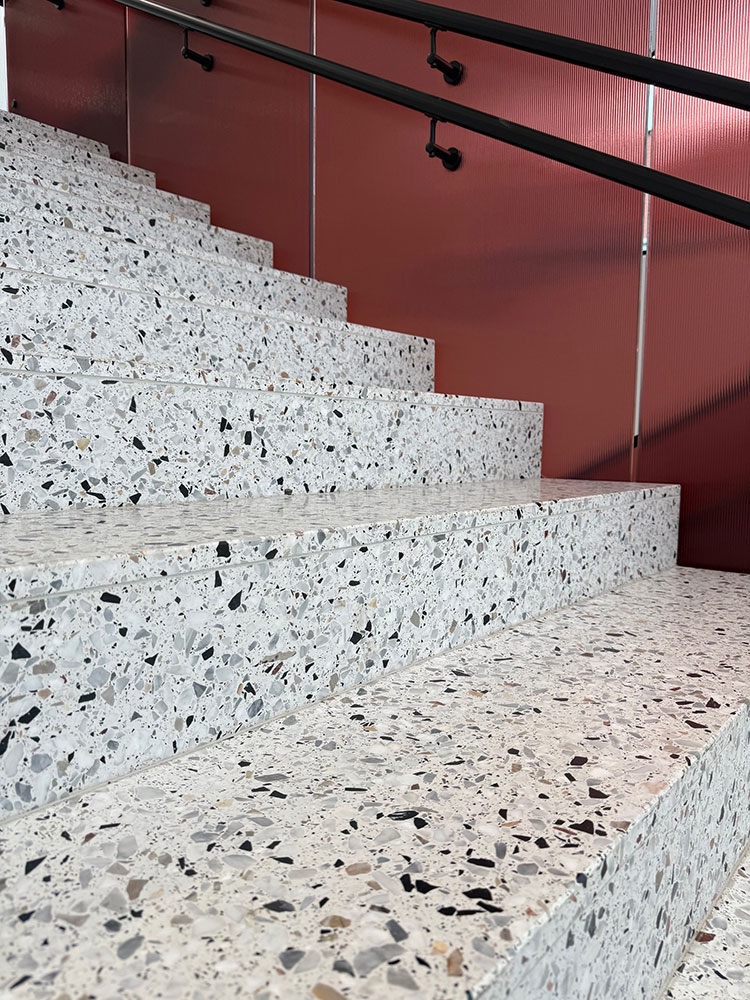 Detail pravé teracové dlažby s viditelnou mramorovou drtí v detailu schodu